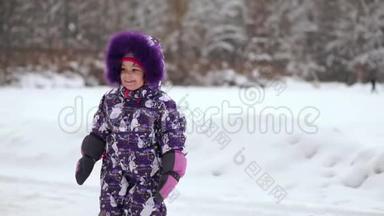 快乐的孩子在冬天的第一场雪中玩耍。 冬暖夏凉的小男孩穿着温暖的雪服走路，玩得开心